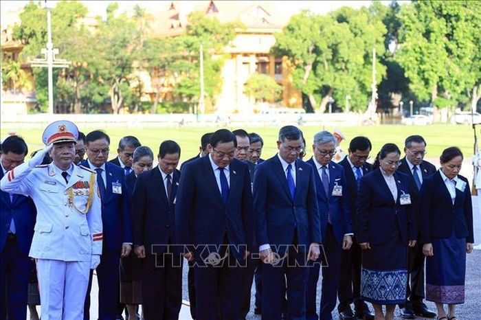 Thủ tướng Lào Sonexay Siphandone và các đại biểu kính cẩn tưởng niệm Chủ tịch Hồ Chí Minh. Ảnh: Tuấn Anh/TTXVN.