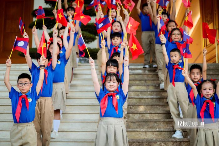 Các cháu thanh thiếu niên, thiếu nhi Thủ đô vẫy cờ hai nước chào đón Thủ tướng Sonexay Siphandone và Đoàn cấp cao Lào.