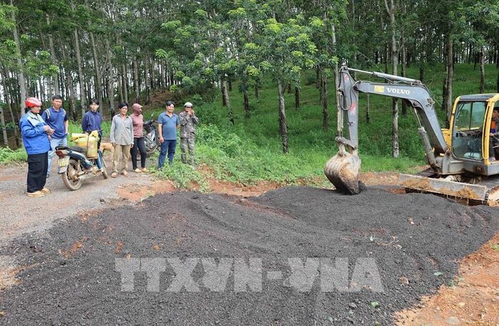 Người dân thôn Sơn Phú, xã Thọ Sơn góp tiền để đổ đá dăm, thêu máy xúc san gạt mặt bằng. Ảnh: Đậu Tất Thành – TTXVN