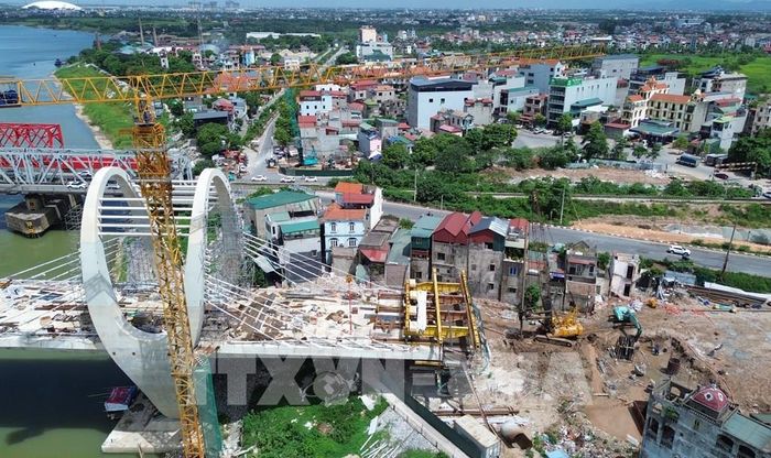 Đường dẫn lên cầu đường bộ phía đường Hà Huy Tập với đường Phan Đăng Lưu (xã Phù Đổng) đang được nhà thầu đẩy nhanh tiến độ thi công sau khoảng thời gian dài vướng mặt bằng sạch. Ảnh: Quốc Khánh - TTXVN 