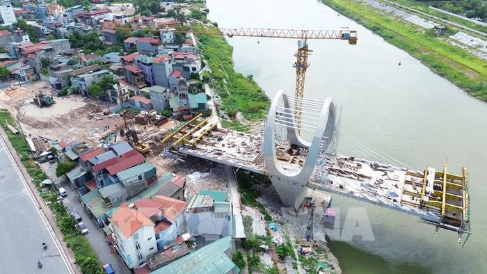 Đường dẫn lên cầu đường bộ phía đường Hà Huy Tập với đường Phan Đăng Lưu (xã Phù Đổng) đang được nhà thầu đẩy nhanh tiến độ thi công sau khoảng thời gian dài vướng mặt bằng. Ảnh: Quốc Khánh - TTXVN 