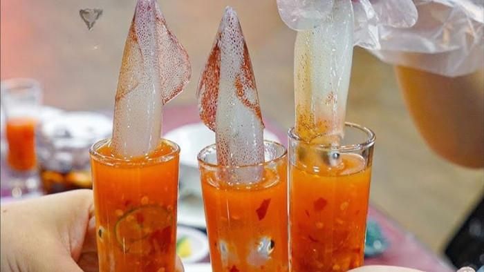 Nhiều du khách cũng thích thú món mực nhảy ăn sống, chấm với nước mắm siêu cay.