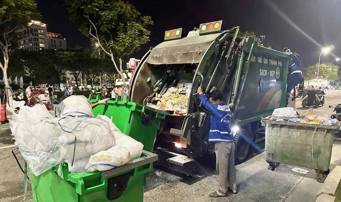 Công ty CP Môi trường đô thị Đà Nẵng bố trí công nhân, phương tiện cơ giới thu gom rác, làm sạch đường phố trong đêm. Ảnh: HOÀNG HIỆP