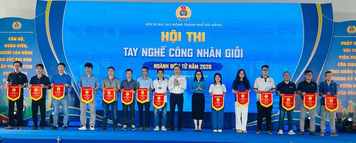 Ban tổ chức Hội thi tay nghề công nhân giỏi ngành điện tử năm 2026 trao cờ lưu niệm cho các thí sinh. Ảnh: KHÁNH HUYỀN