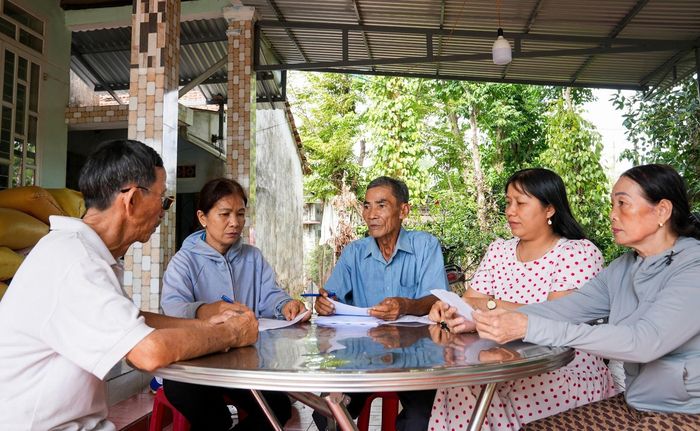 Thôn Bình Thạnh, xã Chiên Đàn phát phiếu lấy ý kiến của nhân dân về đề án thành lập phường. Ảnh: HỒ QUÂN