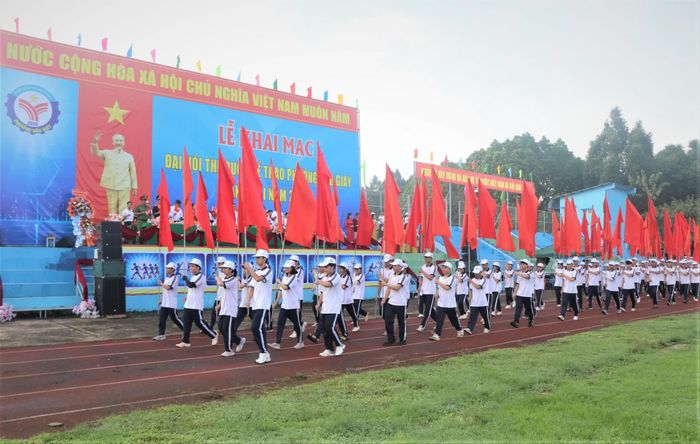 Khối hồng kỳ với 136 lá tượng trưng cho 136 năm Ngày sinh Chủ tịch Hồ Chí Minh diễu hành qua khán đài tại lễ khai mạc đại hội. Ảnh: Nhật Quang