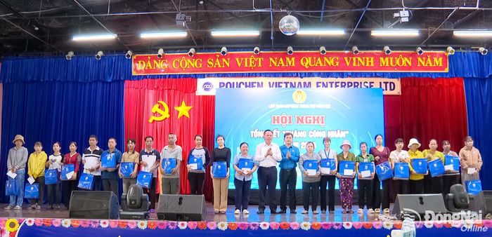 Phó Bí thư Thành ủy Võ Tấn Đức và Thành ủy viên, Phó Chủ tịch Ủy ban MTTQ Việt Nam thành phố, Chủ tịch Liên đoàn Lao động thành phố Đồng Nai Nguyễn Quốc Dũng trao quà cho công nhân có hoàn cảnh khó khăn tại hội nghị. Ảnh: Nguyễn Hòa