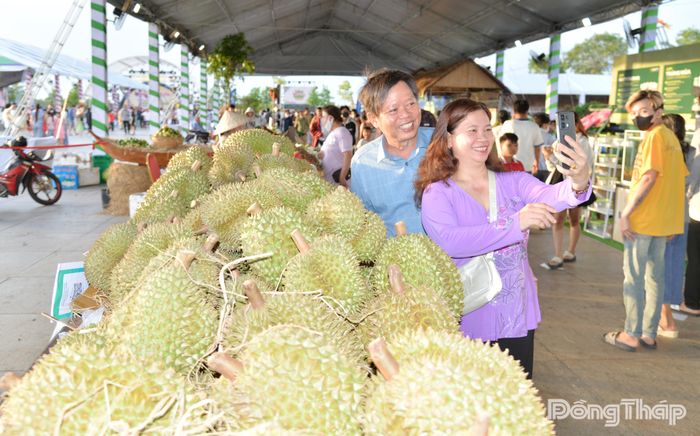 Người dân phấn khởi chụp ảnh bên khu vực trưng bày trái cây đặc sản của Đồng Tháp.
