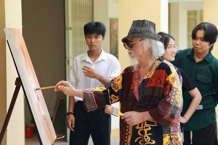  Họa sĩ Đặng Mậu Tựu tham gia vẽ tranh và hướng dẫn cho học sinh, sinh viên. Ảnh: Thanh Sáng 