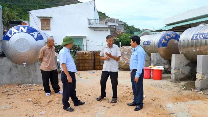  Lãnh đạo phường Quy Nhơn trao đổi với Ban Quản lý dự án cấp nước Hải Minh về cách thức cung cấp cho người dân. Ảnh: Dũng Nhân 