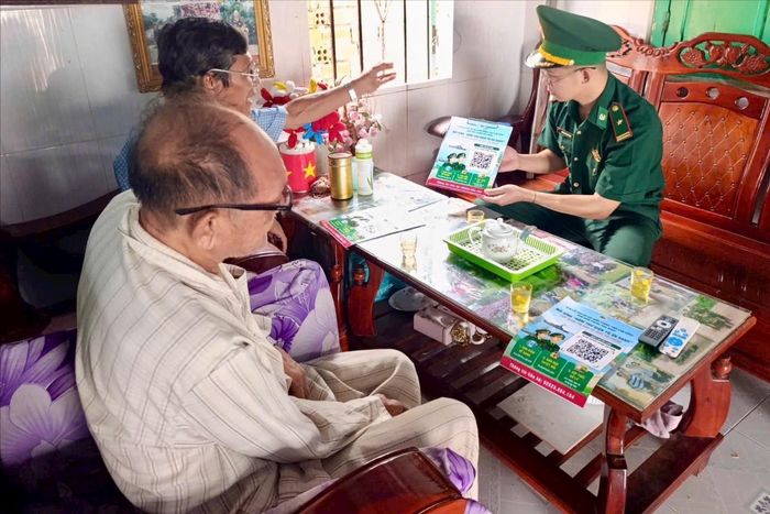 Thiếu tá Huỳnh Văn Phong, Chính trị viên phó Đồn Biên phòng Hòa Minh tuyên truyền, hướng dẫn người dân thao tác gửi hình ảnh, vị trí và thông tin qua mã QR