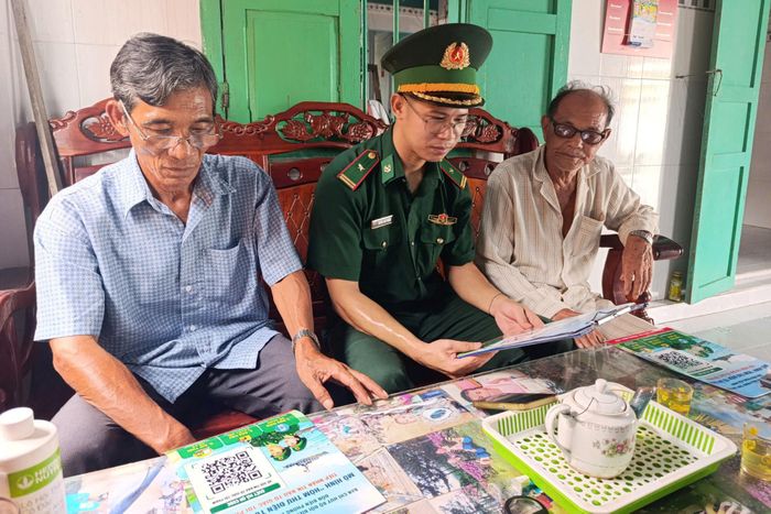 Thiếu tá Huỳnh Văn Phong, Chính trị viên phó Đồn Biên phòng Hòa Minh tuyên truyền, hướng dẫn người dân thao tác gửi hình ảnh, vị trí và thông tin qua mã QR