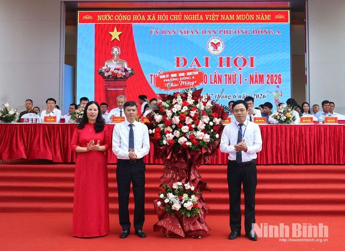 Đồng chí Nguyễn Xuân Hồng, Tỉnh ủy viên, Bí thư Đảng ủy, Chủ tịch HĐND phường Đông A tặng hoa chúc mừng Đại hội. Ảnh: Minh Thuận