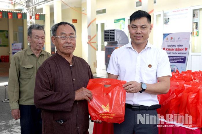Đại diện Hội Doanh nhân trẻ tỉnh tặng quà cho người dân đến khám bệnh.