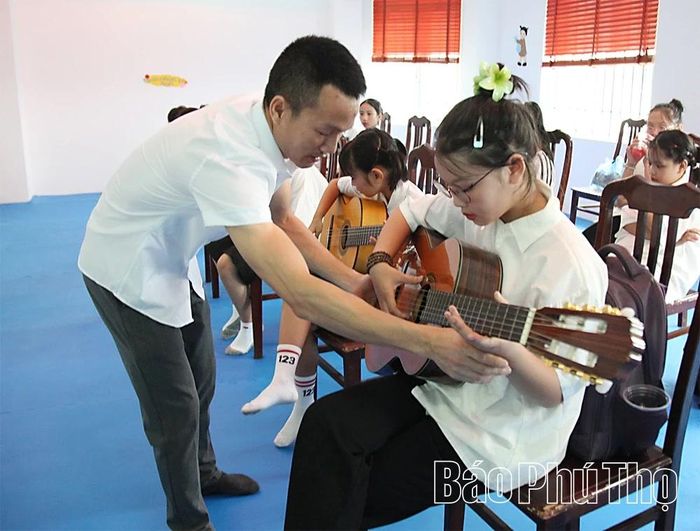 Các em nhỏ tham gia lớp học đàn ghi ta.