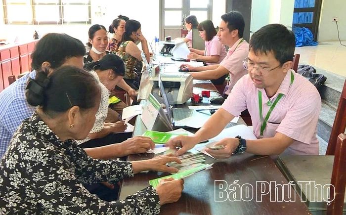 Cán bộ Phòng Giao dịch Ngân hàng CSXH Yên Lạc giải ngân vốn cho các hộ dân.