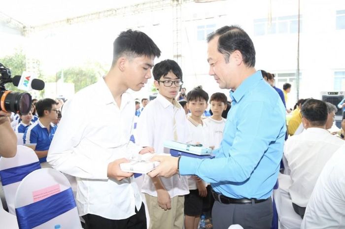  Đại diện Lãnh đạo Tổng Liên đoàn , Bộ Khoa học và Công nghệ, Công đoàn Khoa học và Công nghệ Việt Nam trao quà cho con của các đoàn viên, người lao động có thành tích học tập xuất sắc. Ảnh: Đức Minh. 