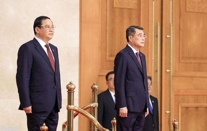 Thủ tướng Lê Minh Hưng và Thủ tướng nước Cộng hòa Dân chủ Nhân dân Lào Sonexay Siphandone thực hiện nghi lễ chào cờ hai nước.