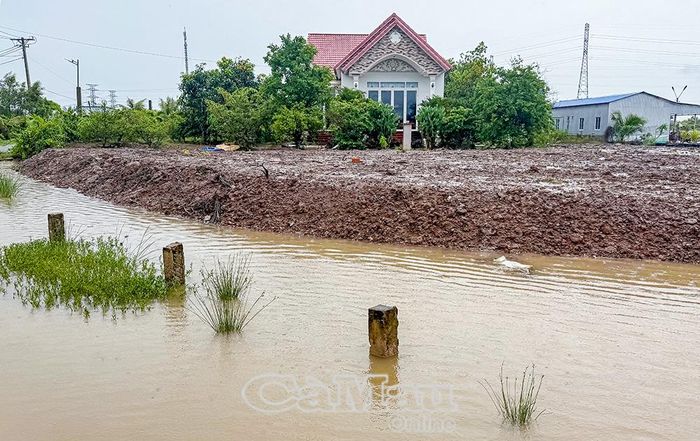 Đường giao thông ngập sâu, chỉ còn nhìn thấy hàng cọc lộ giới khi mưa lớn.