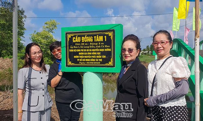 Các nhà tài trợ chụp ảnh lưu niệm bên cây cầu mới.