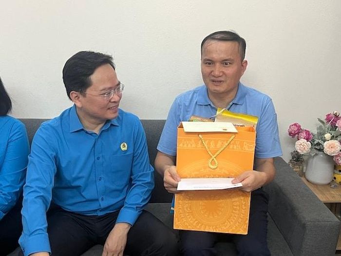 Chủ tịch Tổng Liên đoàn Lao động Việt Nam Nguyễn Anh Tuấn (bên trái) thăm, tặng quà anh Cao Văn Tuấn, công nhân sản xuất - Công ty TNHH Nissei Electric Hà Nội. Ảnh: Kiều Vũ