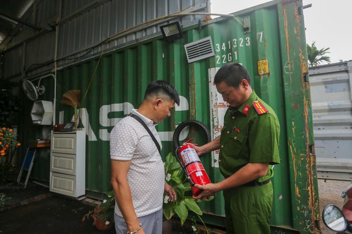 Công an xã Nam Phù hướng dẫn sử dụng các loại bình chữa cháy tại các cơ sở trên địa bàn. Ảnh: Khánh Huy
