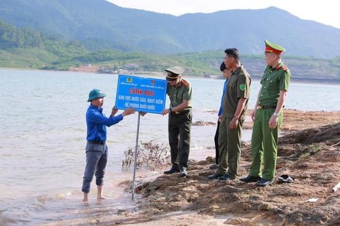 Công an xã Cẩm Lạc phối hợp với Đoàn Thanh niên xã cắm các biển cảnh báo, tuyên truyền nhắc nhở người dân về việc phòng chống đuối nước. Ảnh: TL.
