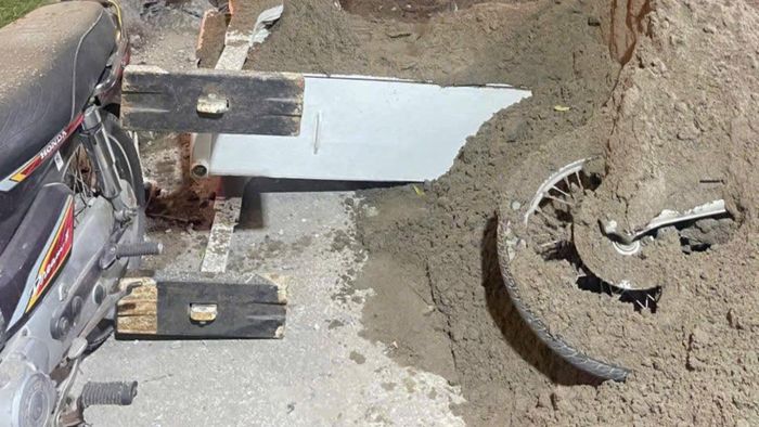 Cát trên xe tải đổ xuống vùi lấp xe máy.