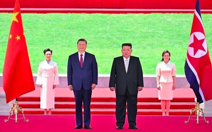 Chủ tịch Trung Quốc Tập Cận Bình (trái) và lãnh đạo Triều Tiên Kim Jong-un trong lễ đón. Ảnh: FACEBOOK/XI MOMENT
