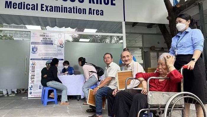 Nhân viên công tác xã hội hỗ trợ người bệnh cao tuổi thăm khám bệnh.