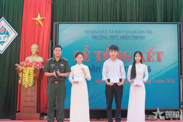 Thiếu tá Nguyễn Văn Sáu trao học bổng tặng Lê Thanh Hoàn cùng các em học sinh trong Chương trình "Nâng bước em tới trường - Con nuôi Đồn Biên phòng".