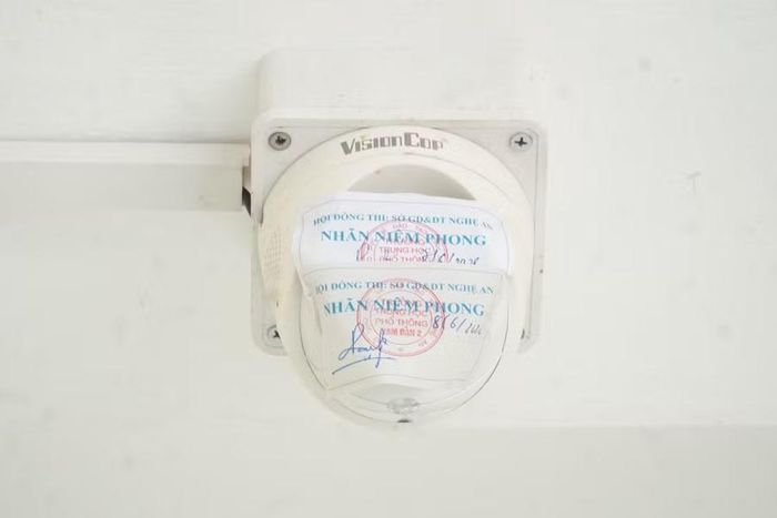 camera ở ngoài hành lang khu hiệu bộ Trường THPT Nam Đàn 2 (không sử dụng trong kỳ thi) được niêm phong với chữ ký của người phụ trách điểm thi. Ảnh: Hồ Lài
