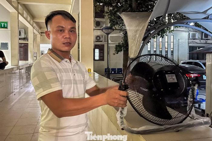 Giữa đêm khuya, người đàn ông vẫn phải ra cổng bệnh viện mua thêm quạt để nghỉ ngơi.