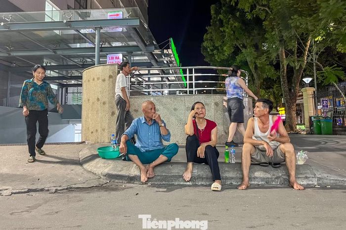 Tại Bệnh viện Hữu nghị Việt Đức, dù đã bước sang ngày mới nhưng nhiều người nhà bệnh nhân vẫn ngồi ngoài khuôn viên hoặc dưới những tán cây để tránh cảm giác ngột ngạt trong các khu vực kín.