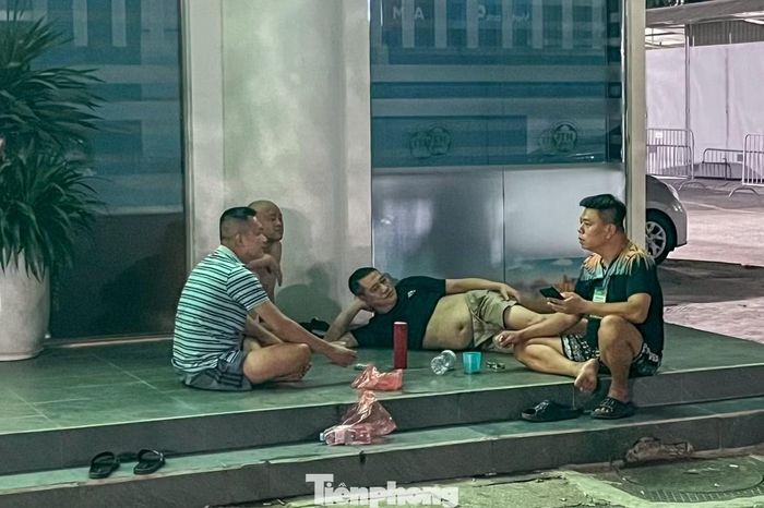 Không ngủ được vì oi bức, nhiều người nhà bệnh nhân ngồi trò chuyện với nhau trong đêm để quên đi cảm giác mệt mỏi và căng thẳng trong thời gian chờ đợi kết quả điều trị.