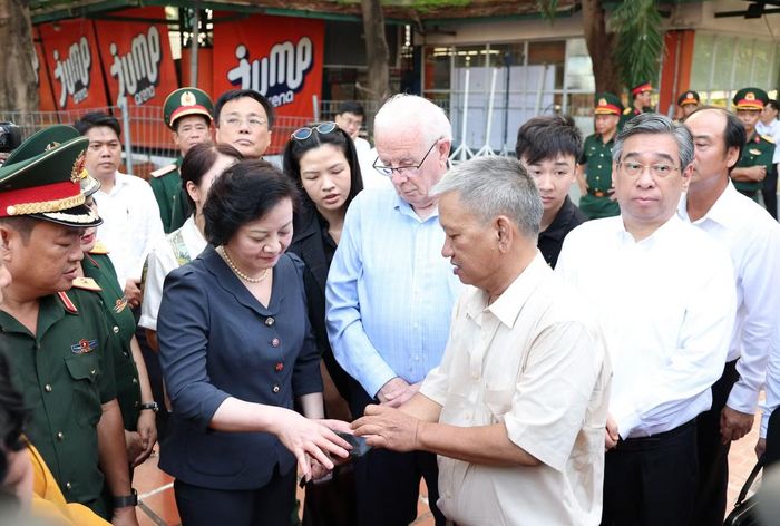 Phó Thủ tướng Phạm Thị Thanh Trà nghe kiến trúc sư Nguyễn Xuân Thắng chia sẻ về quá trình tìm kiếm, xác định danh tính hài cốt liệt sĩ tại Công viên Lê Thị Riêng.
