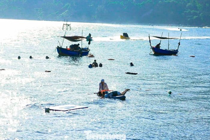 Vào khung giờ từ 15h-18h, lượng người đổ về bãi đá tăng đáng kể. Nhiều người mang theo kính lặn, áo phao và các dụng cụ vui chơi dưới nước để trải nghiệm biển.