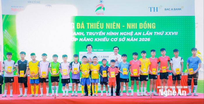 Các đồng chí: Võ Trọng Hải - Phó Bí thư Tỉnh ủy, Chủ tịch UBND tỉnh; Nguyễn Đình Hùng - Ủy viên Ban Thường vụ Tỉnh ủy, Phó Chủ tịch Thường trực Ủy ban MTTQ Việt Nam tỉnh trao 18 suất quà, mỗi suất trị giá 1 triệu đồng, cho các vận động viên có hoàn cảnh khó khăn nỗ lực vươn lên trong học tập và cuộc sống. Ảnh: Thành Duy