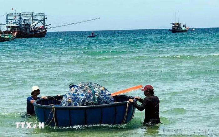 Ngư dân xã Thăng An, thành phố Đà Nẵng đưa rác thải biển vào bờ. (Ảnh Trần Tĩnh/TTXVN)