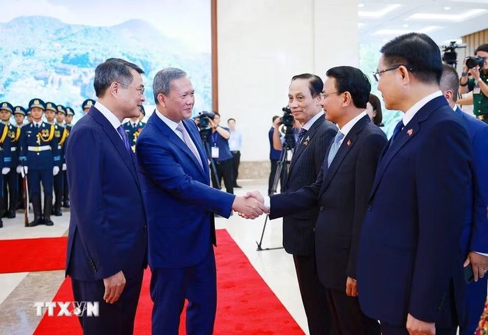 Thủ tướng Lê Minh Hưng giới thiệu với Thủ tướng Campuchia Hun Manet thành viên đoàn Việt Nam tham dự lễ đón. (Ảnh: Dương Giang/TTXVN)