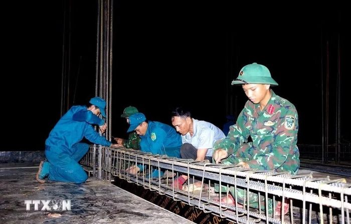 Trên các công trường, màu áo xanh của người lính hòa cùng màu áo công nhân tạo nên không khí lao động sôi nổi, khẩn trương. (Ảnh: TTXVN phát)
