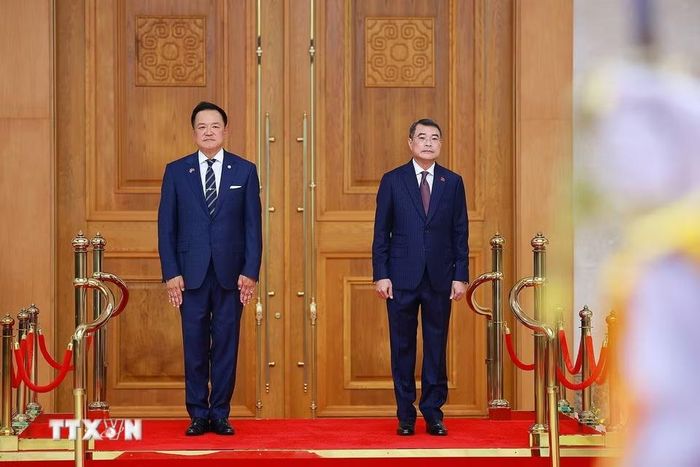 Thủ tướng Lê Minh Hưng và Thủ tướng Vương quốc Thái Lan Anutin Charnvirakul nghe quân nhạc cử Quốc thiều hai. nước. (Ảnh: Dương Giang/TTXVN)