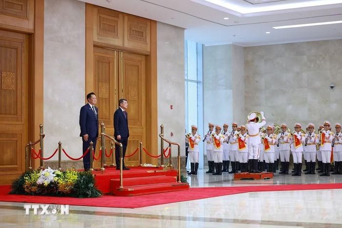 Thủ tướng Lê Minh Hưng và Thủ tướng Vương quốc Thái Lan Anutin Charnvirakul nghe quân nhạc cử Quốc thiều hai. nước. (Ảnh: Dương Giang/TTXVN)