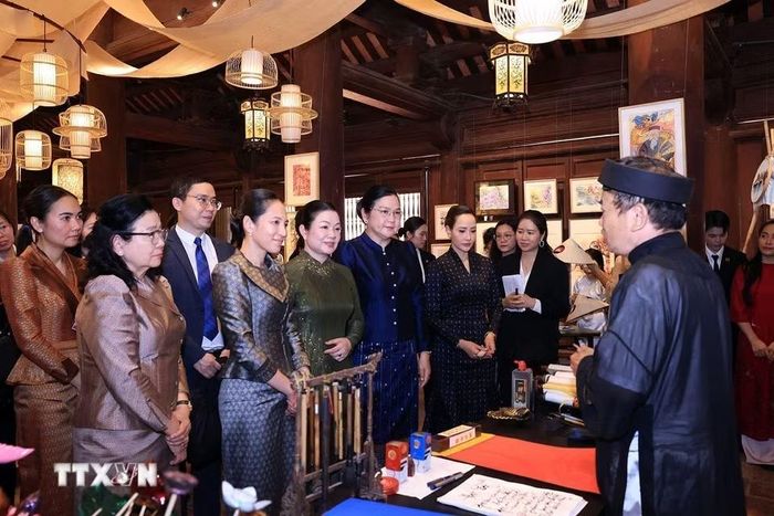Các Phu nhân nghe giới thiệu về nghệ thuật thư pháp của Việt Nam. (Ảnh: Tuấn Anh/TTXVN)
