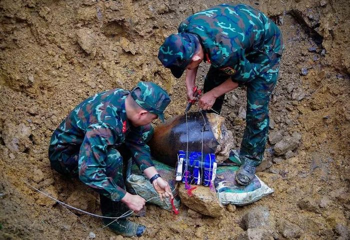 Lực lượng công binh tiến hành đặt kích nổ đối với một phần quả bom còn tồn sót sau chiến tranh. (Ảnh: Trọng Đạt/TTXVN)