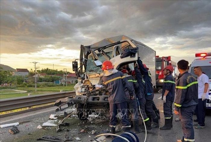 Lực lượng chức năng nỗ lực giải cứu nạn nhân mắc kẹt trên xe tải. Ảnh: TTXVN phát