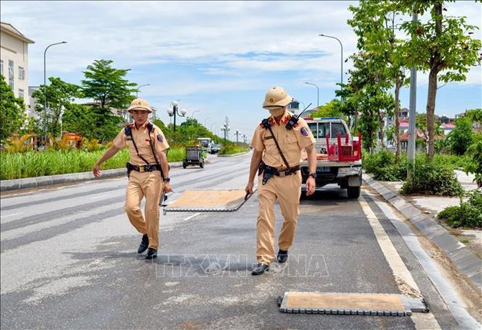 Cán bộ Đội Cảnh sát giao thông số 8, Phòng Cảnh sát giao thông Hà Nội triển khai cân tải trọng lưu động đối với các phương tiện vận chuyển vật liệu xây dựng trên địa bàn xã Thường Tín. Ảnh: Trung Nguyên/TTXVN