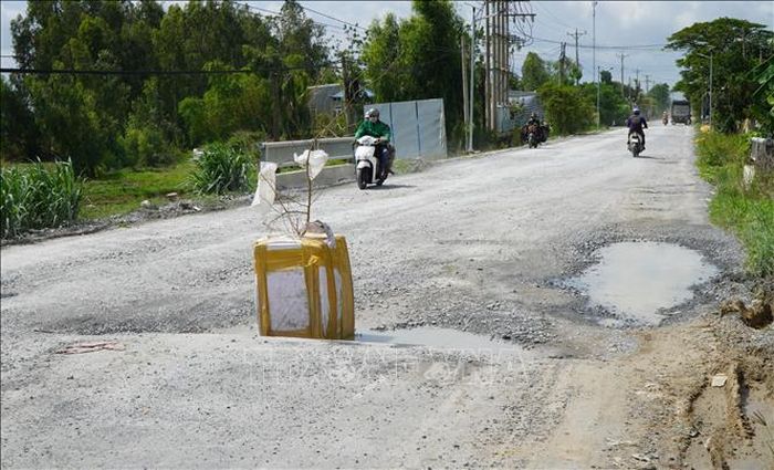 Người dân đặt vật cảnh báo giúp người tham gia giao thông né “ổ gà” trên Quốc lộ 30 đoạn qua xã Tân Hồng.