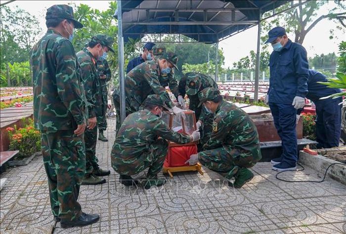 Lực lượng chuyên môn tiến hành đưa hài cốt liệt sĩ ra khỏi mộ để lấy mẫu giám định.