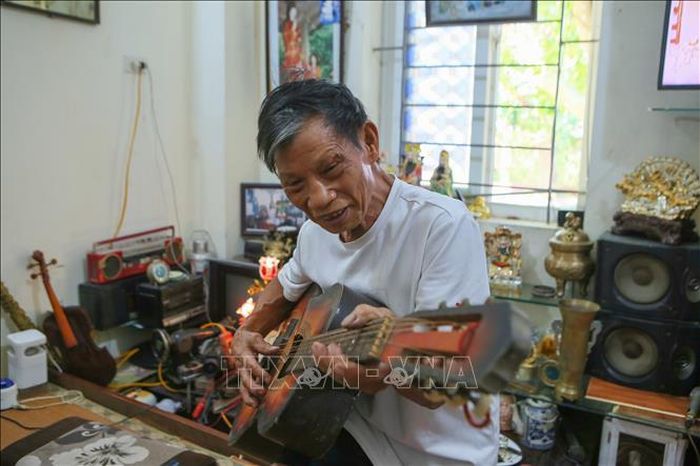 Ông Vũ Ngọc Oánh giải trí cùng cây đàn mang theo đến chỗ ở tạm thời tại Khu nhà ở sinh viên tập trung, phường Nam Định.